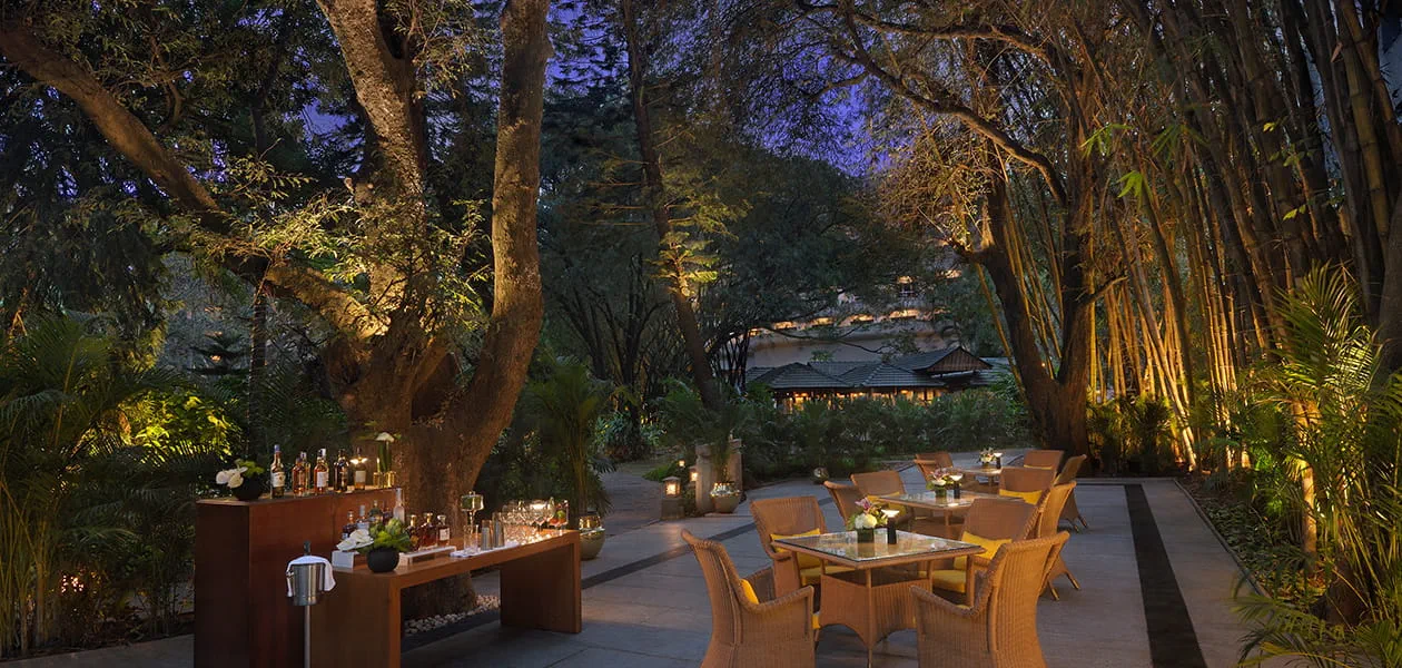 Outdoor dining area at The Oberoi Bengaluru's garden setting.