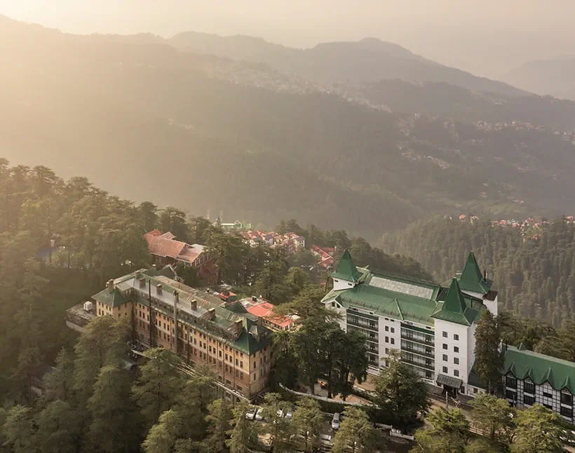 Aerial view of forested hills, resembling The Oberoi Cecil, Shimla.